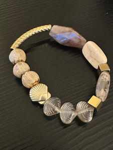 Beige coloured gemstones & gold shell bead with gold textured tube bead bracelet on black background 
