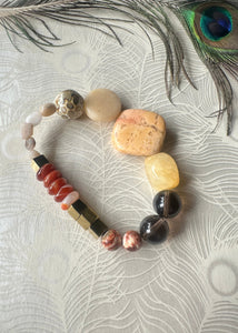 Carnelian, peach stone, Smokey quartz, hematite gemstone bracelet on peacock feather background