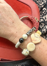 Load image into Gallery viewer, Carnelian, peach stone, Smokey quartz, hematite gemstone &amp; ceramic beaded bracelet on a womans wrist with leopard print pants &amp; a red handbag