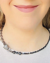 Load image into Gallery viewer, Black toned pave&#39; crystal embellished panther with green crystal eyes. Hematite Stone beads &amp; Czech crystal beaded necklace with gunmetal chain worn on a model wit blonde hair &amp; pink lips