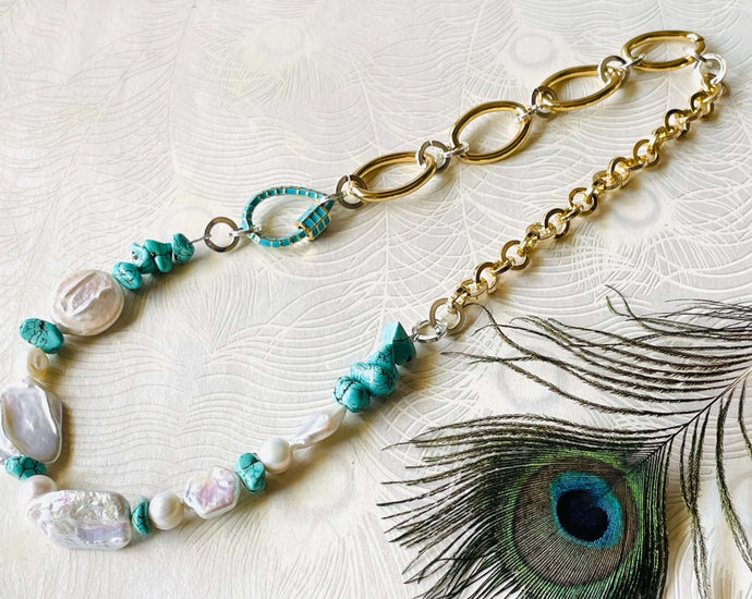 Keshi Pearl handmade necklace with turquoise beads & turquoise inlay teardrop screw lock carabiner clasp and a mix of silver & gold toned long lasting anti tarnish handmade chain sitting on a peacock patterned background with feather