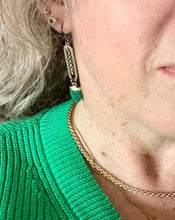 Load image into Gallery viewer, Gold plated loops with sterling silver chain centre, gunmetal loops &amp; ear hooks with Malachite style pointed feature stones on model ear with blonde hair &amp; green knit