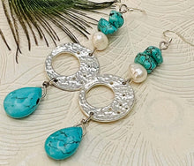 Load image into Gallery viewer, Earrings with a Turquoise teardrop shape stone hanging from silver disc with pearl &amp; turquoise stone on a silver ear hook against a white background with a peacock feather
