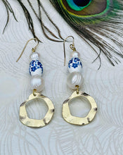 Load image into Gallery viewer, Blue &amp; white flower ceramic bead earrings with Genuine Freshwater Pearls Gold Plated textured feature discs with 14Ct Gold Filled ﻿ear hooks sitting on a background of patterned paper and a peacock feather  Edit alt text
