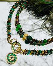 Load image into Gallery viewer,  Two green malachite &amp; gold beaded necklaces with gold cain on mirrored background with peacock feather