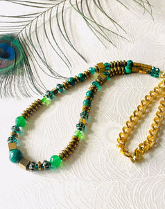green malachite & gold beaded necklace with gold cain on white background with peacock feather
