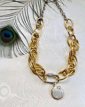 Load image into Gallery viewer, freshwater round Keshi Pearl set in a gold plated bezel pendant with handmade mixed metal statement chain necklace with micro pave&#39; cubic zircons on a  carabiner locking clasp &amp; white gold plating. sitting on peacock patterned pearl paper with peacock feather in left corner