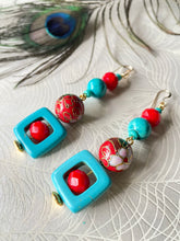 Load image into Gallery viewer, Turquoise square &amp; red crystal earrings with red enamel cloisonné bead &amp; 14ct gold filled ear hooks on beige background with peacock feather