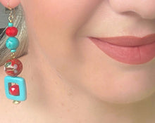 Load image into Gallery viewer, Turquoise square &amp; red crystal earrings with red enamel cloisonné bead &amp; 14ct gold filled ear hooks on a blonde haired model with red lips