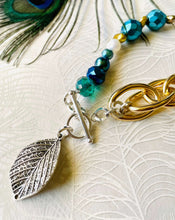 Load image into Gallery viewer, Close up of Silver leaf hanging off sterling silver toggle clasp with turquoise &amp; blue crystal &amp; gold chain bracelet